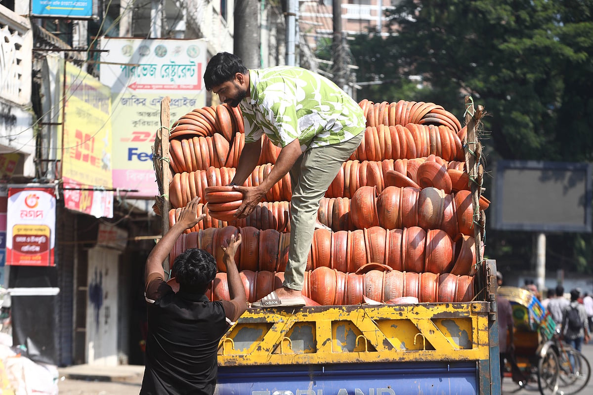 পিকআপ থেকে মাটির পাতিল নামিয়ে দোকানে সাজানো হচ্ছে। সুরমা মার্কেট, সিলেট (ছবি: আনিস মাহমুদ)