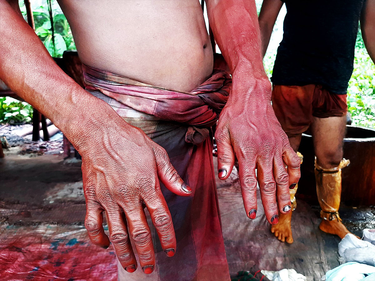 Dye stays on the workers' hands, and they taste its bitterness even at meals.