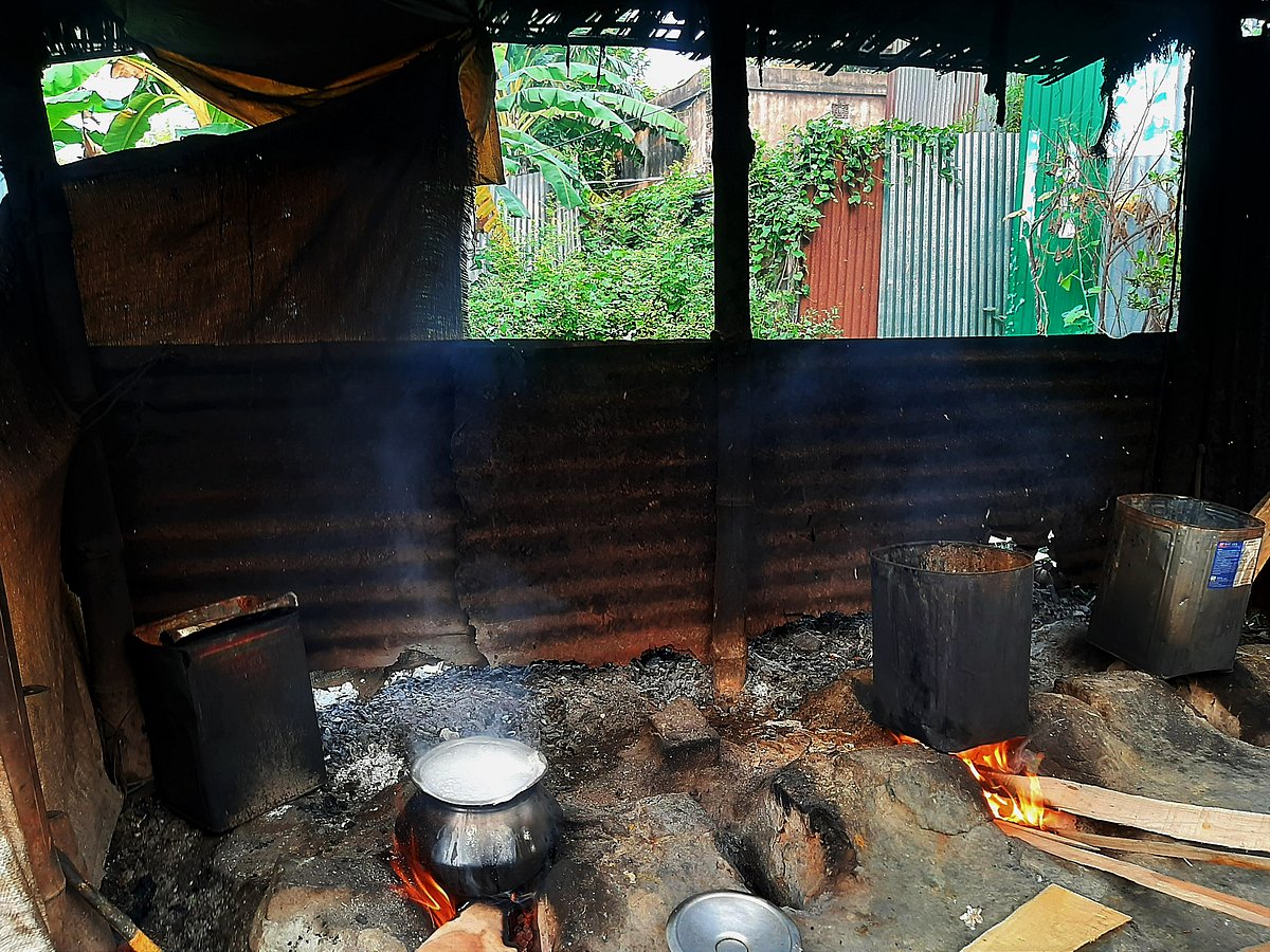 Rice on one stove, dye boiling on the other: an everyday scene in the workers' lives.