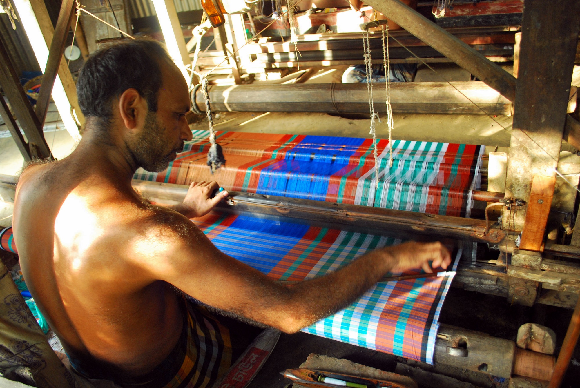 A lungi being woven on a handloom at Dohar in Dhaka district. Photo: Pervez Robin / Wikimedia Commons (CC BY-SA 4.0)