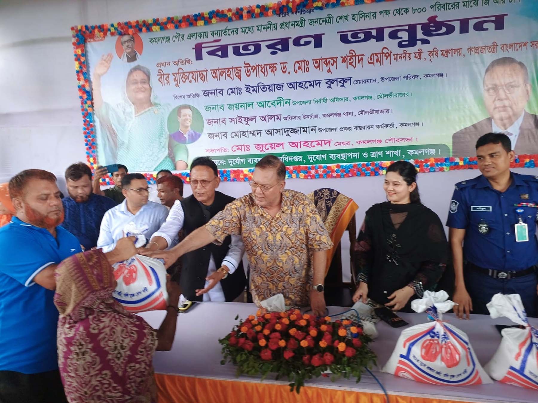 ২০২৪ সালের ২৪ জুন কমলগঞ্জ পৌর এলাকায় বন্যাদুর্গত পরিবারের মধ্যে চাল ও শুকনা খাবার বিতরণ; ছবিটি আগের একটি বন্যার। ছবি: তথ্য অধিদপ্তর (পিআইডি) / উইকিমিডিয়া কমন্স (পাবলিক ডোমেইন)