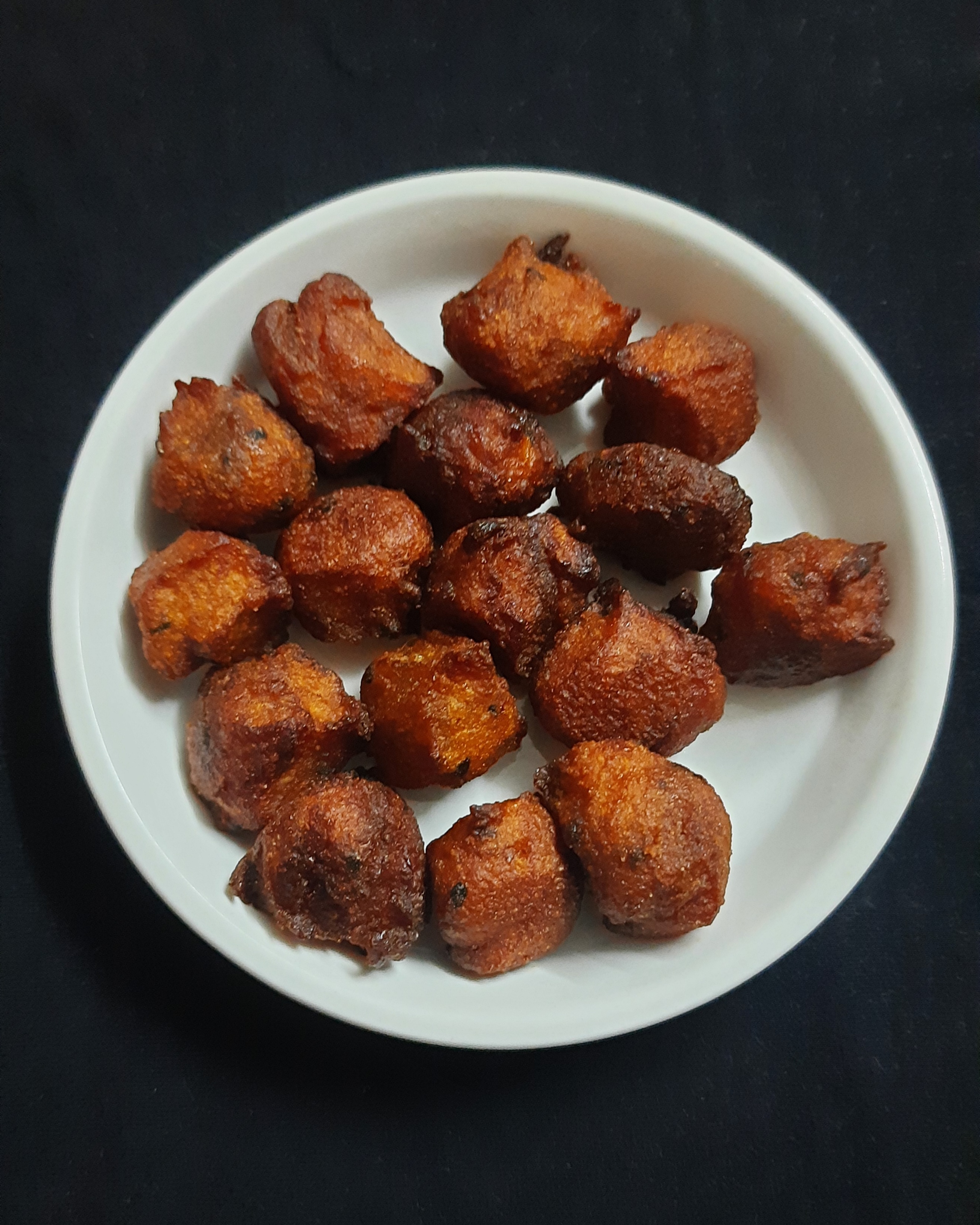 কাঁঠাল, চাল, নারকেল, লবণ ও গুড় দিয়ে তৈরি একই ধাঁচের মিষ্টি ভাজা পিঠা 'হালাসিনা হান্নু মুলকা'; ছবিটি ভারতের। ছবি: Prajna Prabhu / উইকিমিডিয়া কমন্স (সিসি বাই-এসএ ৪.০)